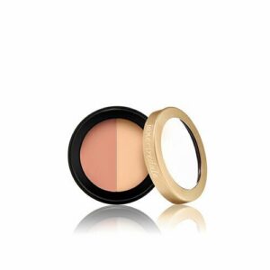 Round dual-shade makeup compact with beige powders and a gold lid, reflected on a white surface