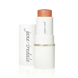White lipstick case with peach shade exposed, standing upright beside its cap branded with Jane Iredale.