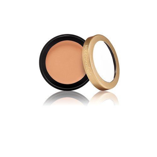 510510088jpg – Damara Luxury Spa Vancouver Laura Mercier cream concealer in a black circular case with a gold lid resting beside the open container on a white background.