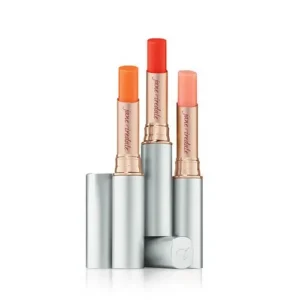Three lipstick tubes in silver cases with orange, coral, and red shades standing upright.