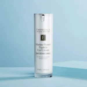 White cylindrical bottle of Eminence Marine Flower Peptide Eye Cream against a pale blue background, with product label visible.