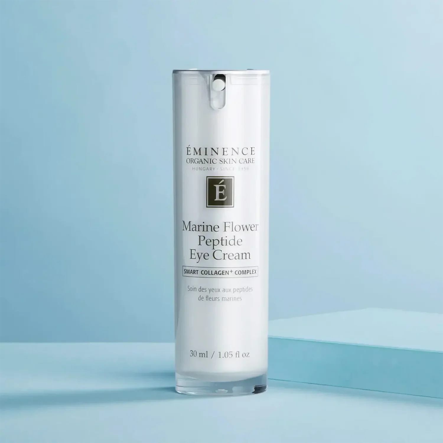 Eminence_Organics_Marine_Flower_Peptide_Eye_Cream_1_x2000_562a0a81-2539-45c4-967f-fef41843ee82 – Damara Luxury Spa Vancouver White cylindrical bottle of Eminence Marine Flower Peptide Eye Cream against a pale blue background, with product label visible.