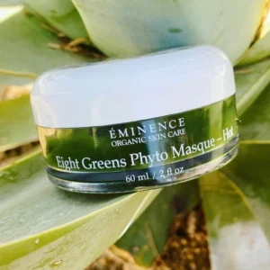 Jar of ÉMINENCE Organic Skin Care Eight Greens Phyto Masque resting on a green plant leaf, 60 ml noted on label