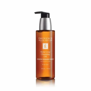 Amber bottle with black pump labeled Eminence Stone Crop Cleansing Oil (150 ml), skincare product image on white background. - Informative product photo