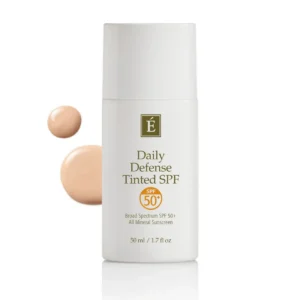 White bottle of É Daily Defense Tinted SPF 50+ sunscreen with beige swatches beside it.