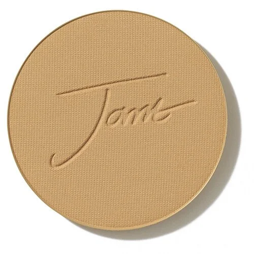 goldentanwebp – Damara Luxury Spa Vancouver Round pressed powder compact in light beige with an embossed cursive signature on the lid, viewed from above.