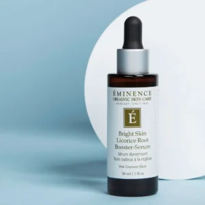 Eminence Bright Skin Licorice Root Booster-Serum bottle with dropper against a blue background, labeled product packaging