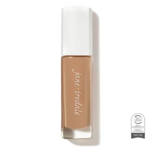 Nude liquid lipstick tube with a white cap photographed from the side, showing the brown shade. The Skin Cancer Foundation seal is visible in the bottom-right corner of the image.